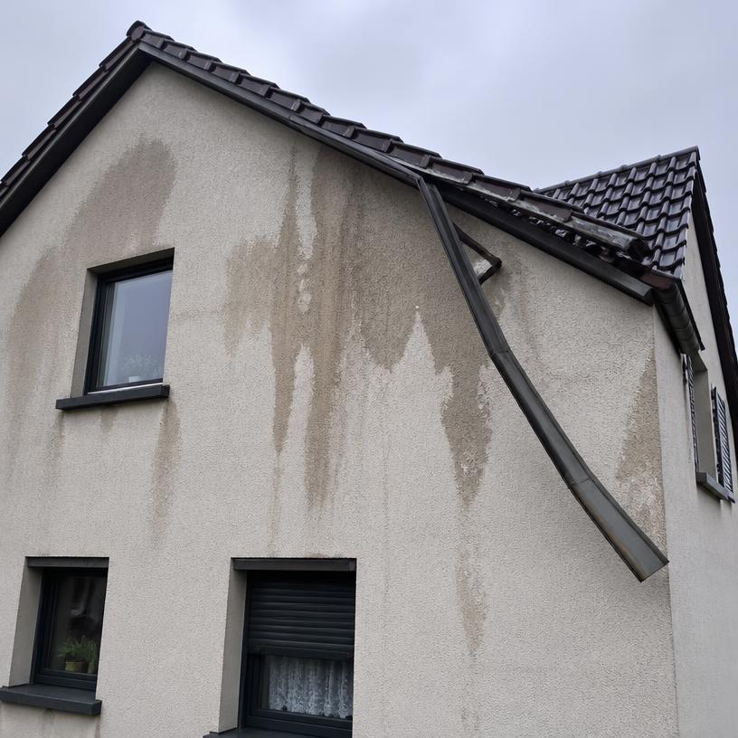 Vom Kunden gesendetes Foto: Wasserflecken an der Giebelwand und lose Regenrinne